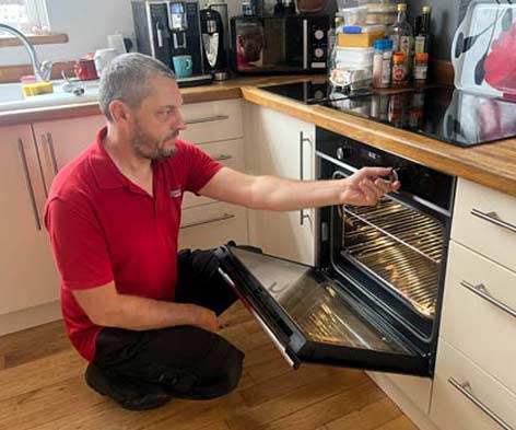 Paul repairing an electric oven in a customer's kitchen